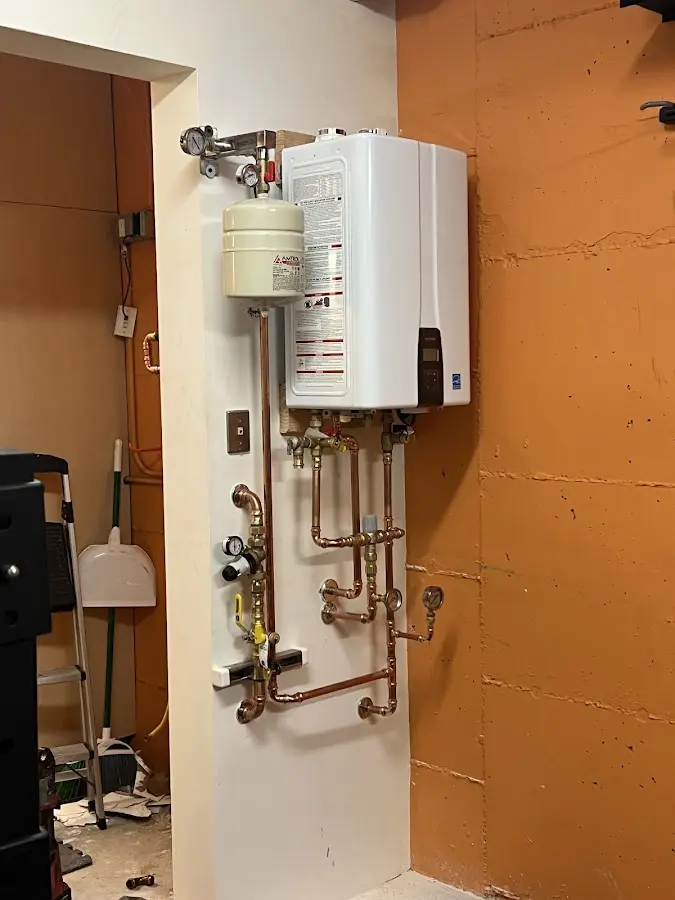 Plumbing technician inspecting water heater connections in West Memphis